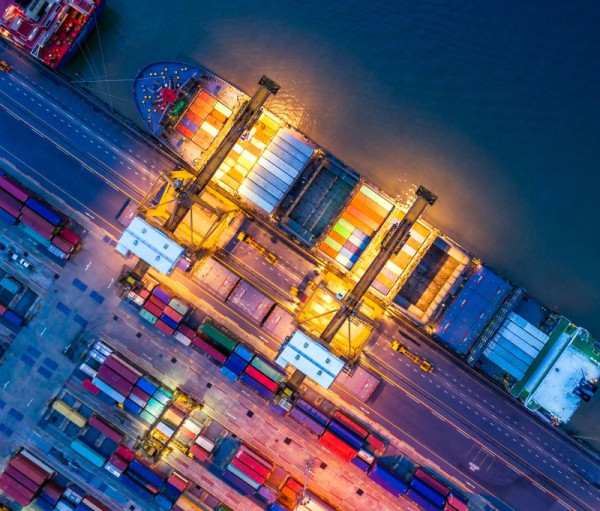 Birds eye view of a ship docked on a wharf filled with cargo 